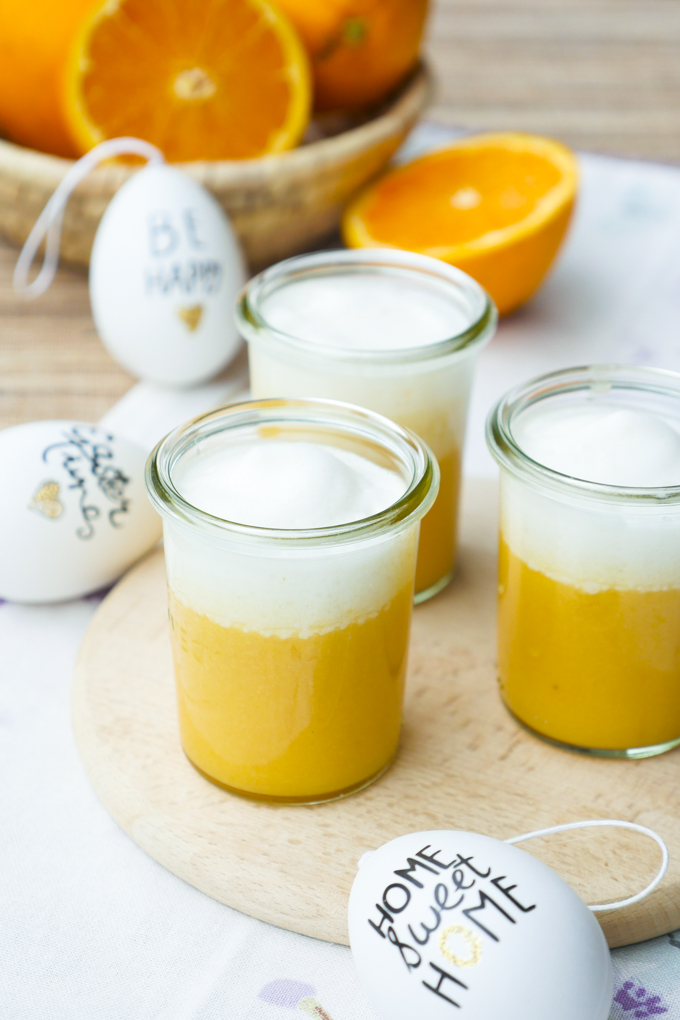 Erfrischender Orangensmoothie mit Nussmus und cremigem Milchschaum