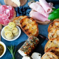 Italienische Brotzeit mit Bruschetta, Schinken, Käse und Toppings