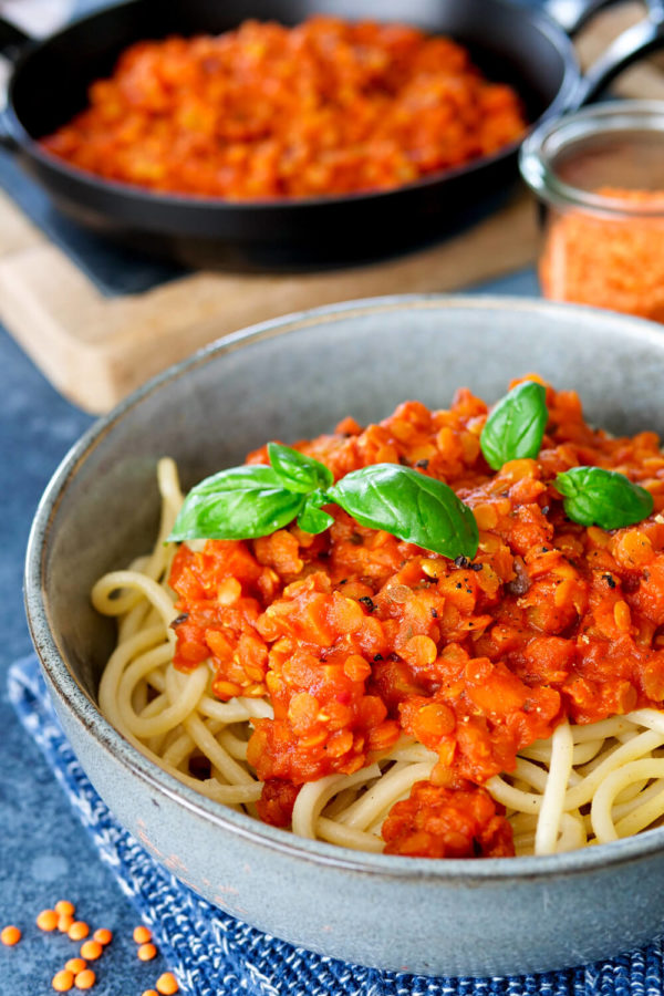 Rote Linsenbolognese mit Spaghetti und Basilikum in der Schüssel