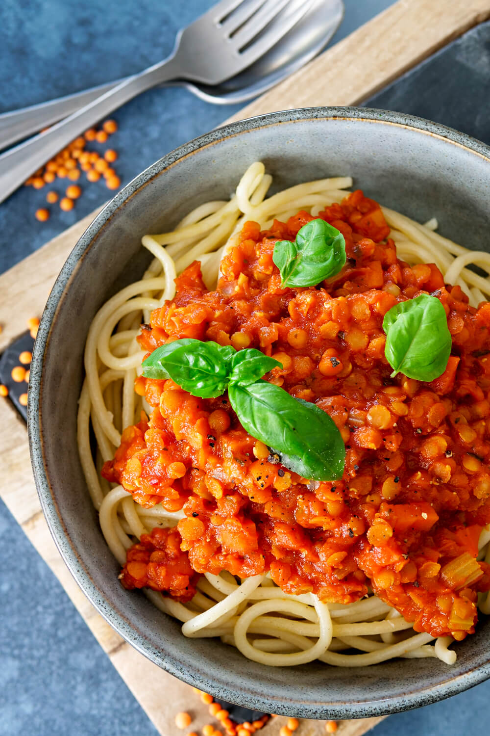 Spaghetti in der Schüssel mit einer Sauce aus roten Linsen und Tomaten mit Basilikum