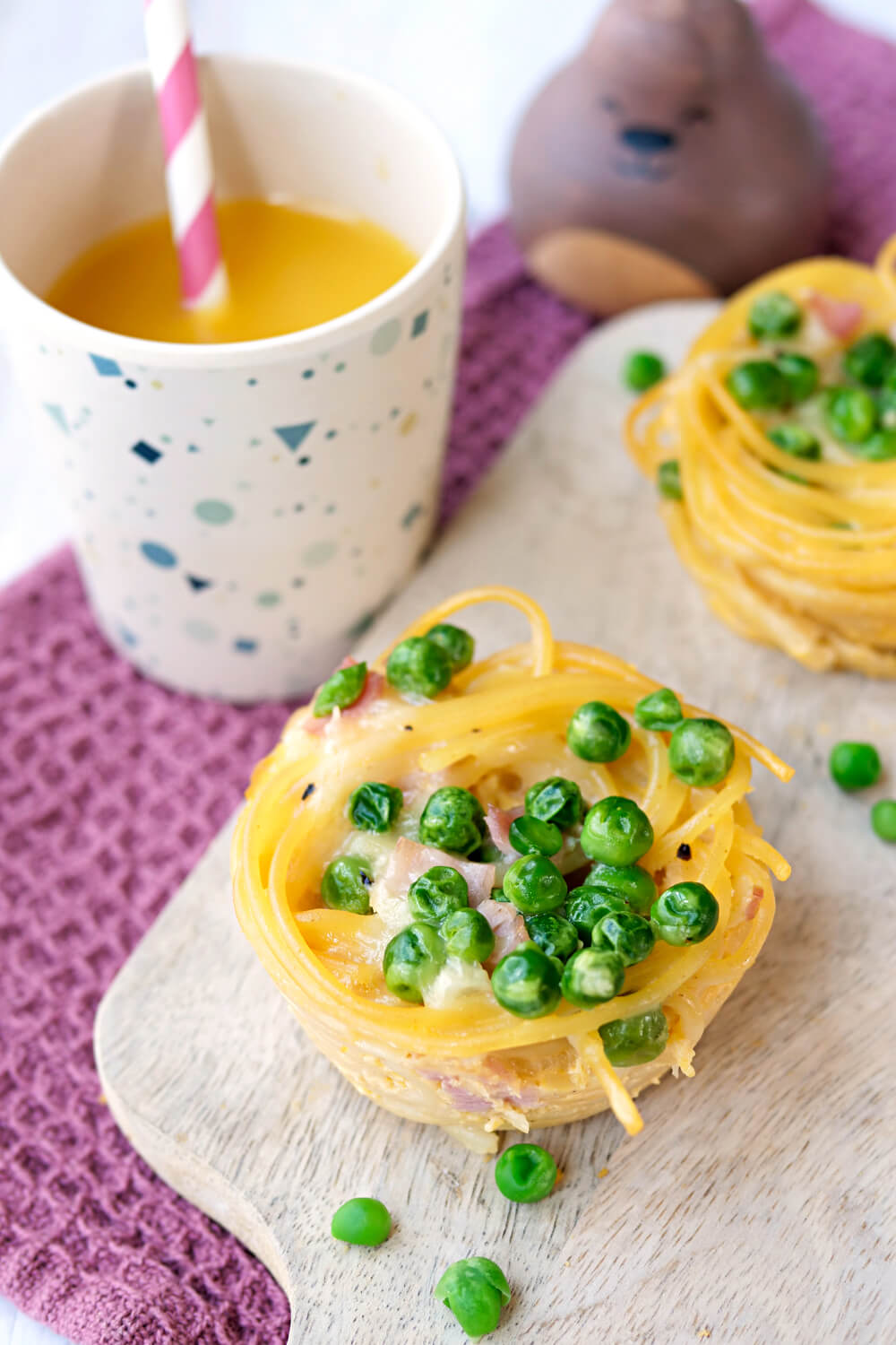Spaghetti-Muffins mit Erbsen und Schinken, dazu ein Becher Orangensaft