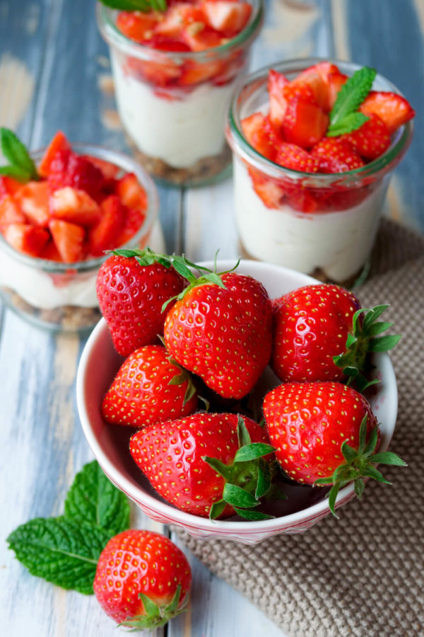 Frische Erdbeeren in der Schüssel mit Erdbeer-Dessert im Glas