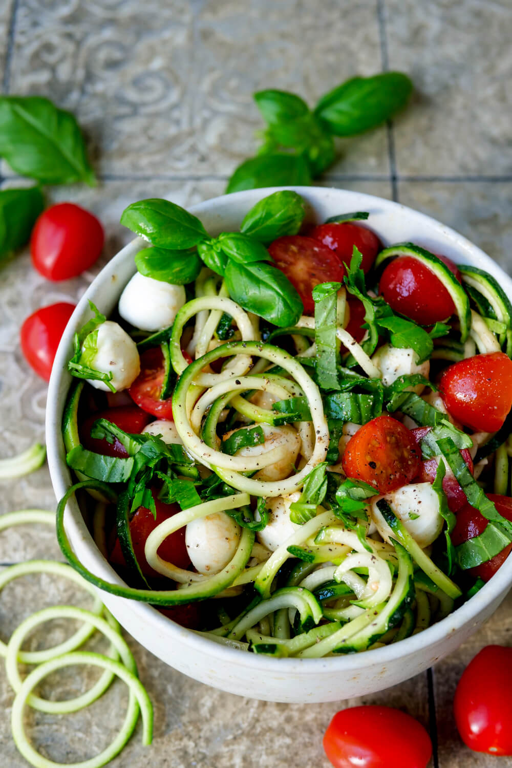 Roher Zucchini-Salat mit Tomaten Mozzarella und Basilikum