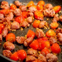 Salsiccia mit Tomaten, Knoblauch und Zwiebeln anbraten