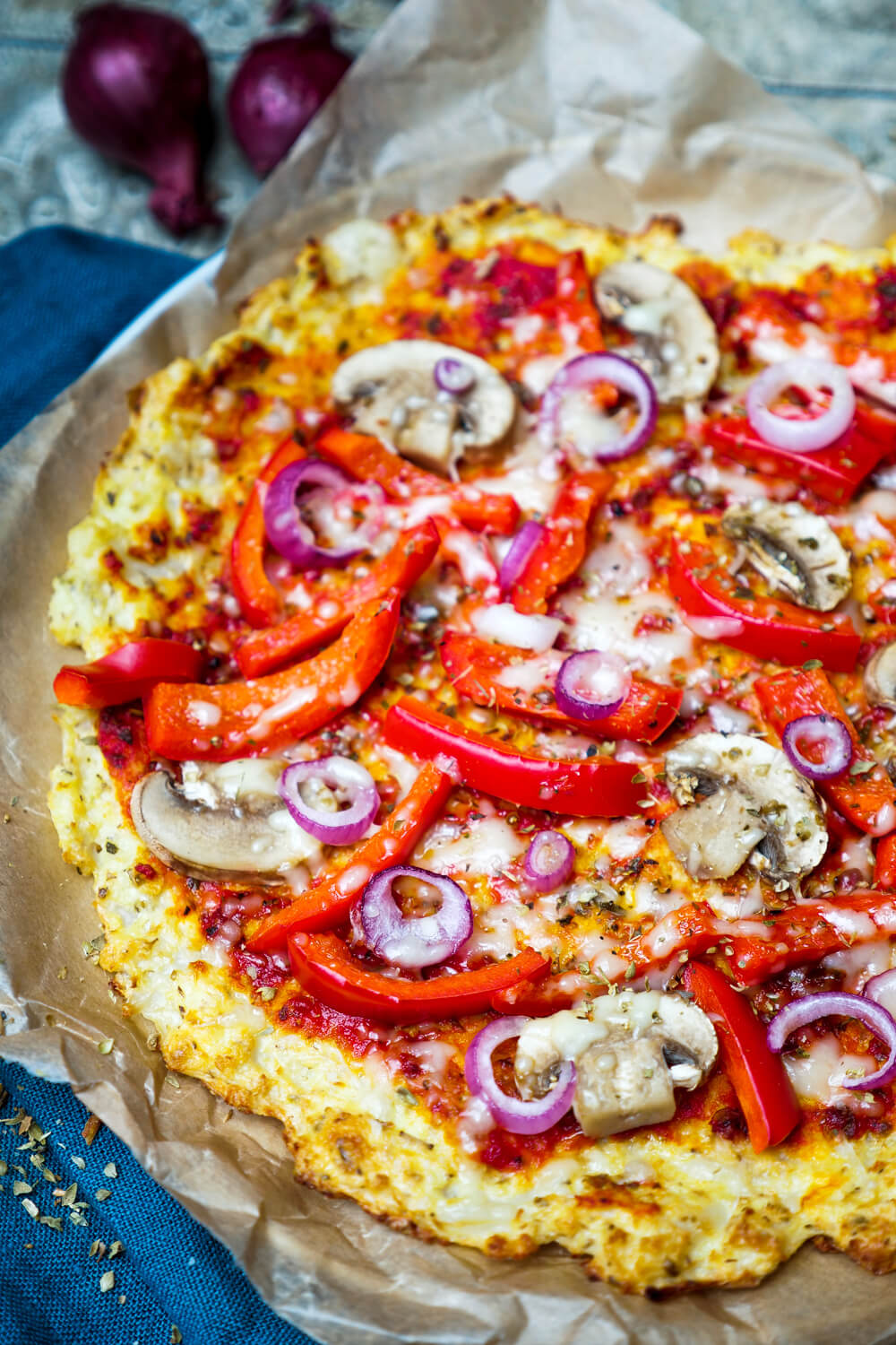 Blumenkohl-Pizza backen und mit Paprika und Champignons belegen