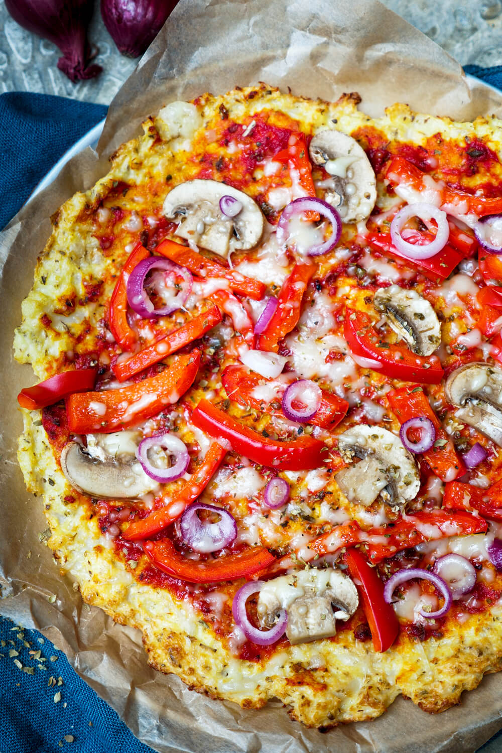 Blumenkohl-Pizza belegt mit Paprika und Champignons