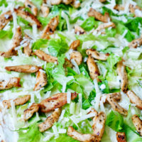 Caesar-Salad-Rolle mit einem Belag aus Dressing, Hähnchen , Römersalat und Parmesan