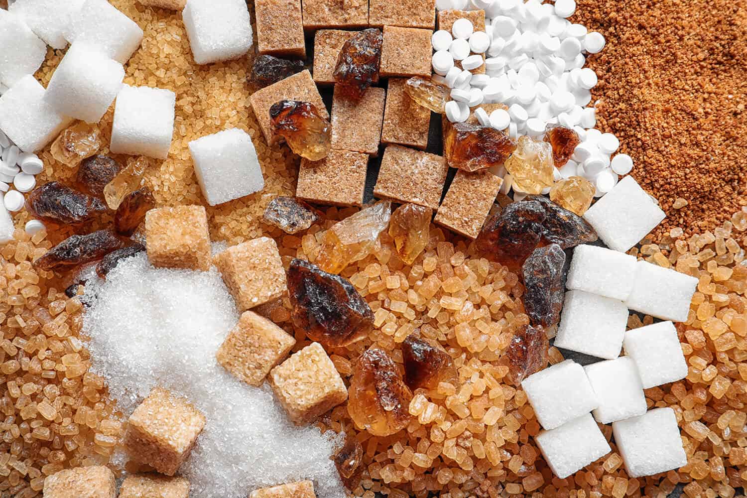 Zucker, Zuckerwürfel, Kandis und Süßstofftabletten in Nahaufnahme