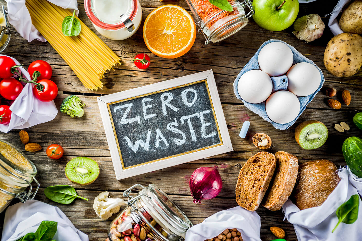 Verschiedene angebrochene Lebensmittel mit Kreidetafel "Zero Waste"