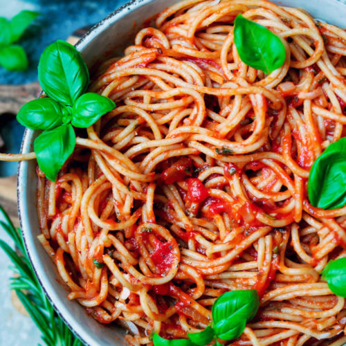 Spaghetti Napoli mit Tomatensauce und Basilikum auf dem Teller