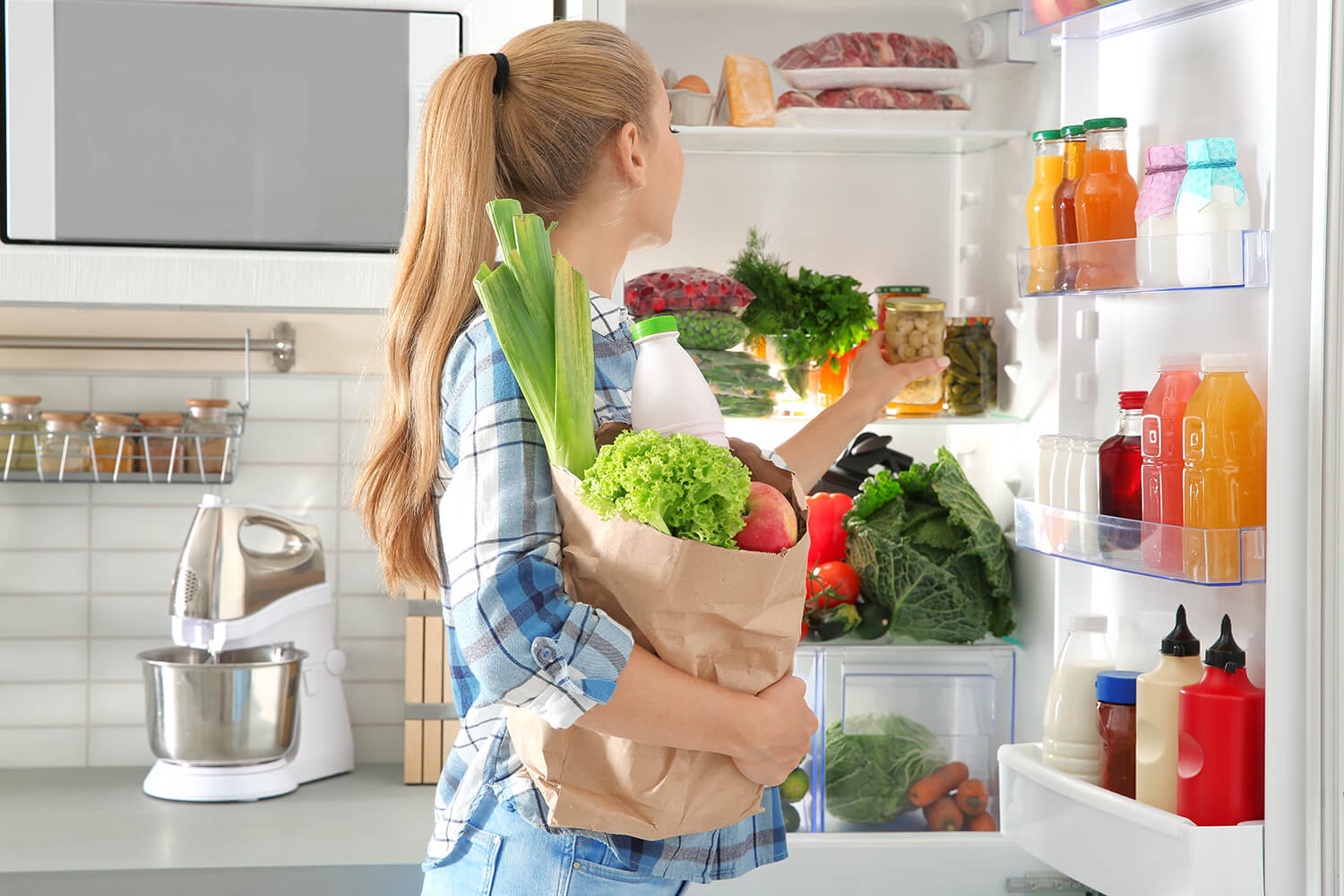 Person, die Lebensmittel in Kühlschrank räumt