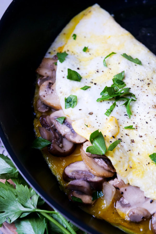 Omelette mit Champignons zusammengeklappt in der Pfanne