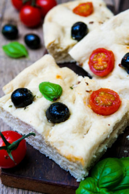 Focaccia Brot mit Tomaten und Oliven in Stücke geschnitten