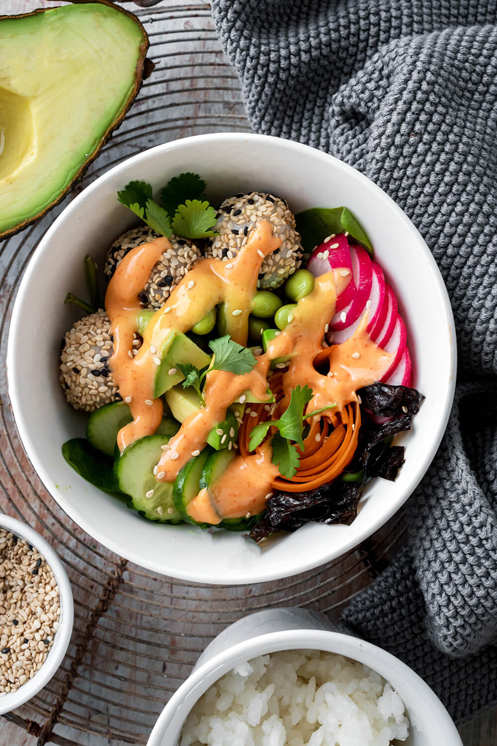 Sushi Bowl mit Sushi-Reis-Bällchen, Edamame, Radieschen, Avocado, Gurken, Möhren und Dressing