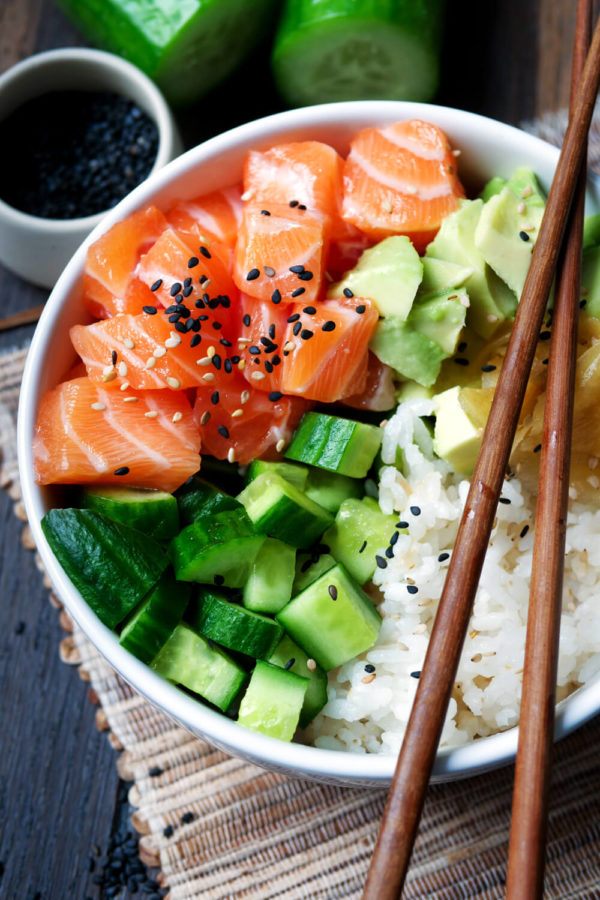 Sushi-Bowl mit Gurke, Lachs, Reis, Avocado und Ingwer in der Schüssel