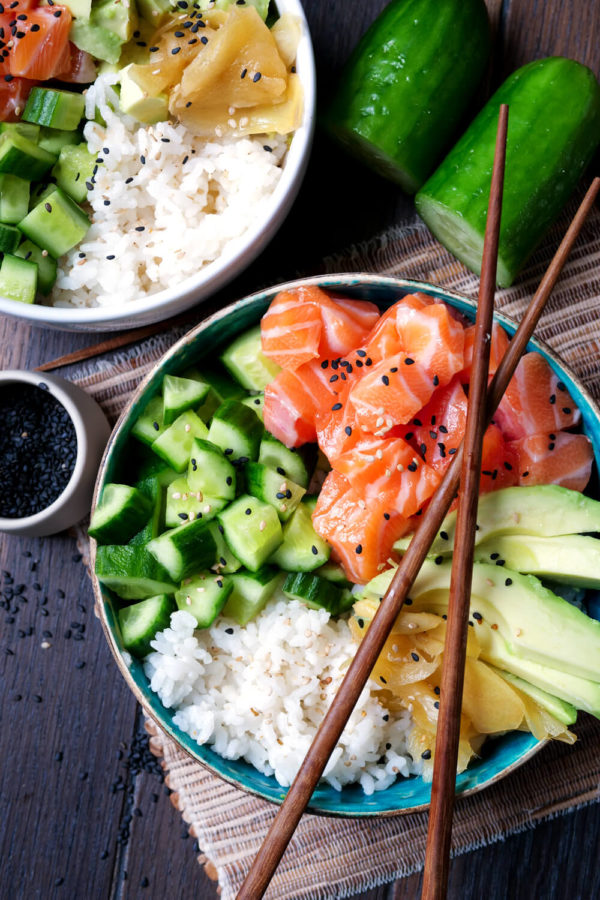 Sushi-Bowl mit Gurke, Lachs, Reis, Avocado und Ingwer in der Schüssel