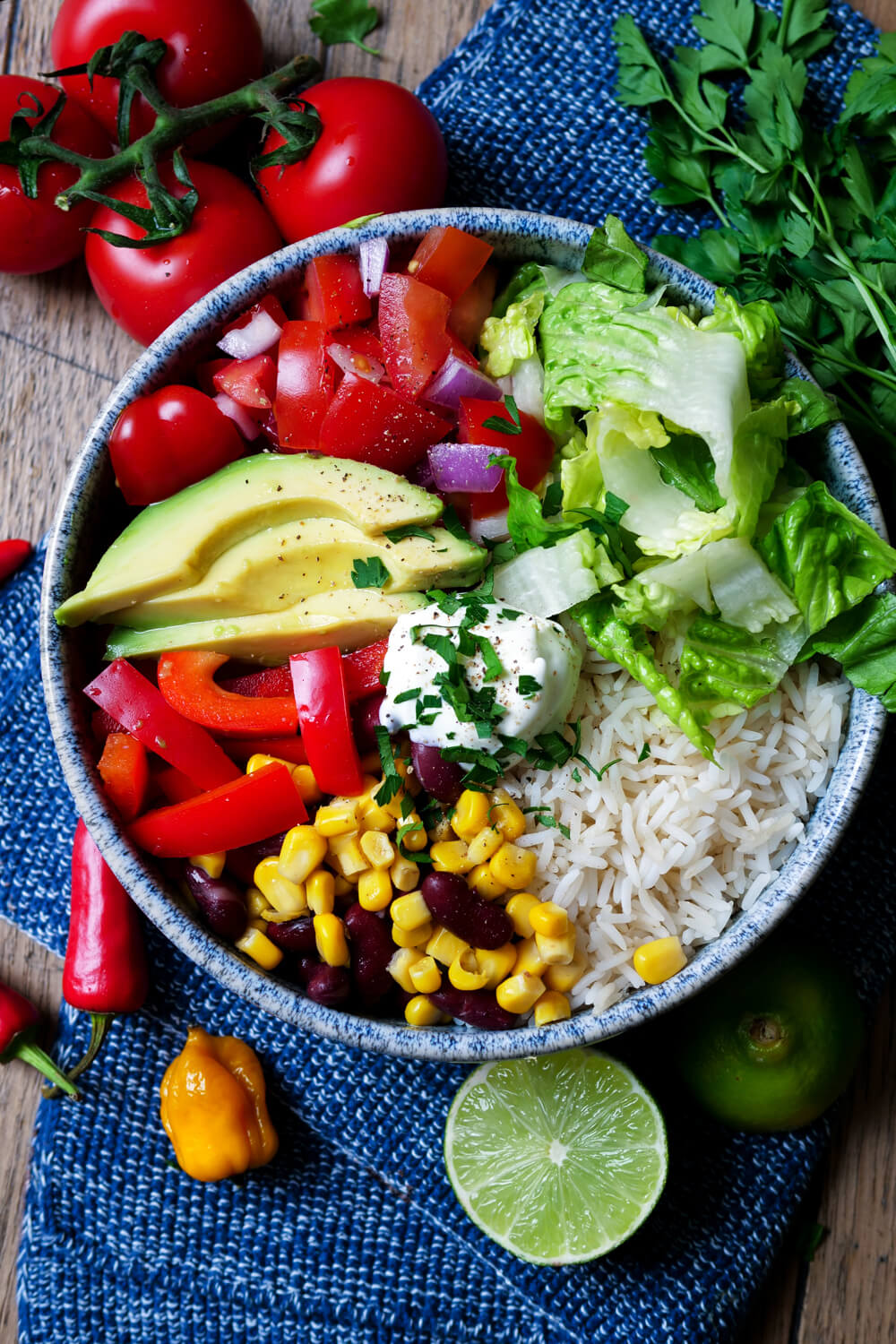 Vegetarische Burrito-Bowl mit Reis, Avocado, Paprika und Mais