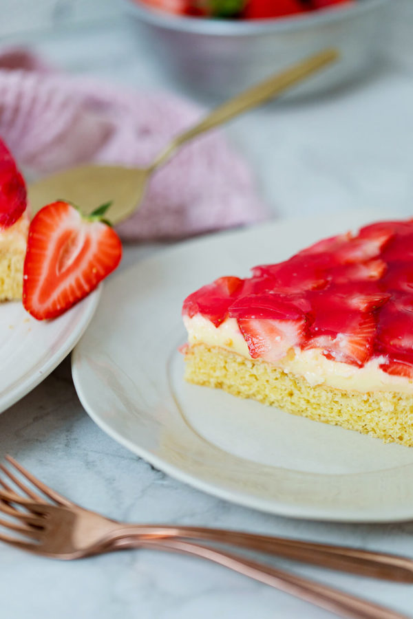 Ein Stück Erdbeeerkuchen mit Pudding auf dem Teller