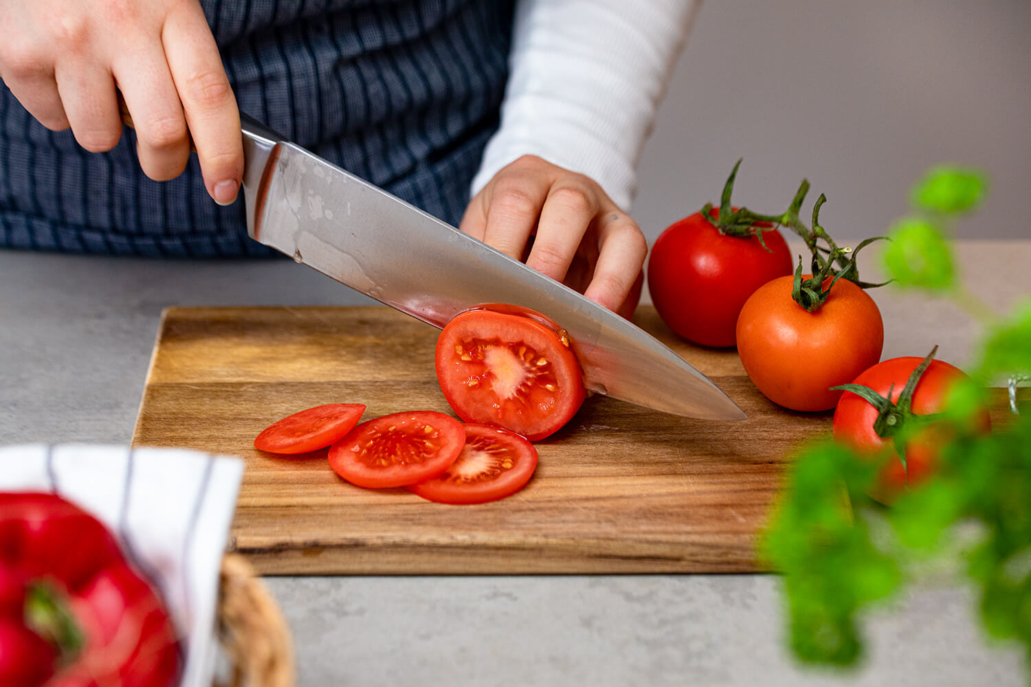 Tomate wird mit scharfem Messer geschnitten