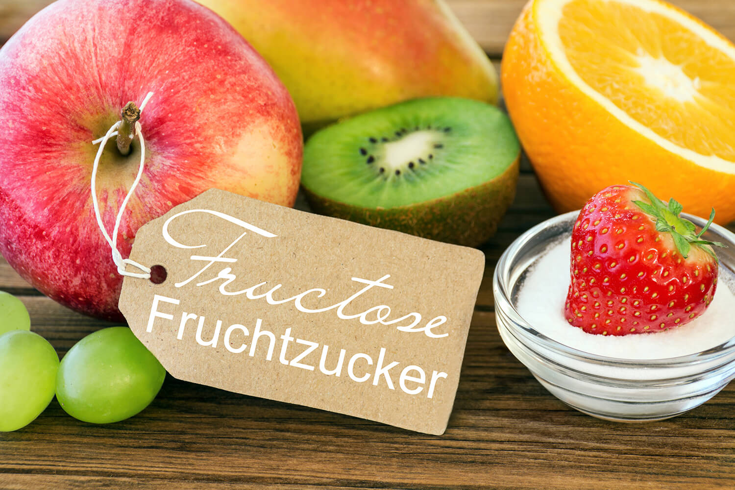 Verschiedenes Obst, ein Apfel trägt ein Schild mit Aufschrift "Fructose"