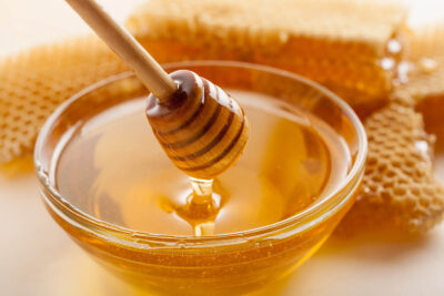 Honig in Glasschale mit Honiglöffel
