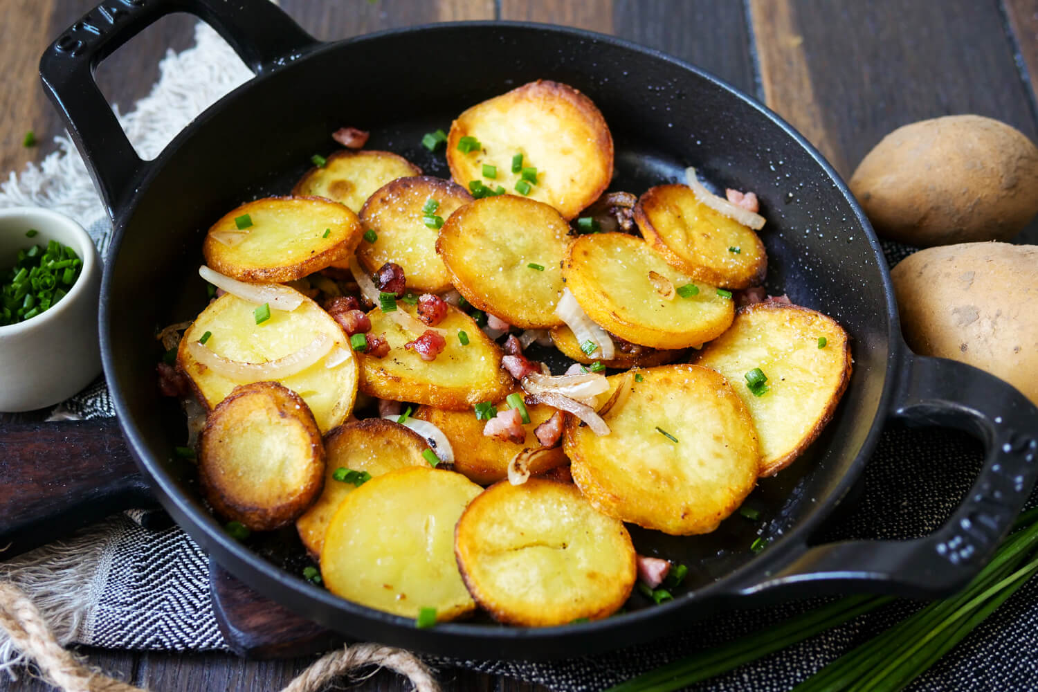 Knusprige Bratkartoffeln mit Zwiebeln und Speck in der Pfanne