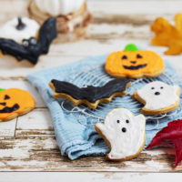 Bunt verzierte Halloween-Kekse mit Kürbis- Fledermaus und Geist-Motiven