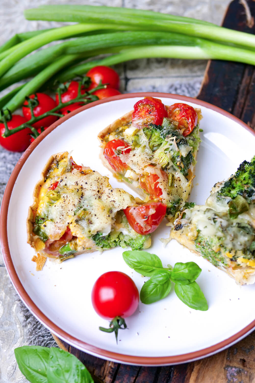 Wrap-Quiche mit Brokkoli, Tomaten und Käse überbacken in Stücke geschnitten