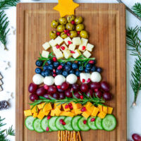 Weihnachtliche Käseplatte mit Trauben, Käasewürfeln und Oliven als Tannenbaum gelegt