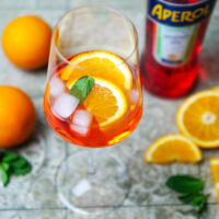 Aperol Spritz mit Orange und Minze im Glas