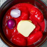 Geschälte Tomaten, Butter und Zwiebel im Topf