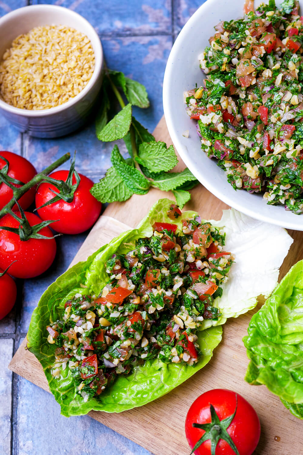 Tabouleh-Salat auf Salatblättern und in einer Schüssel.