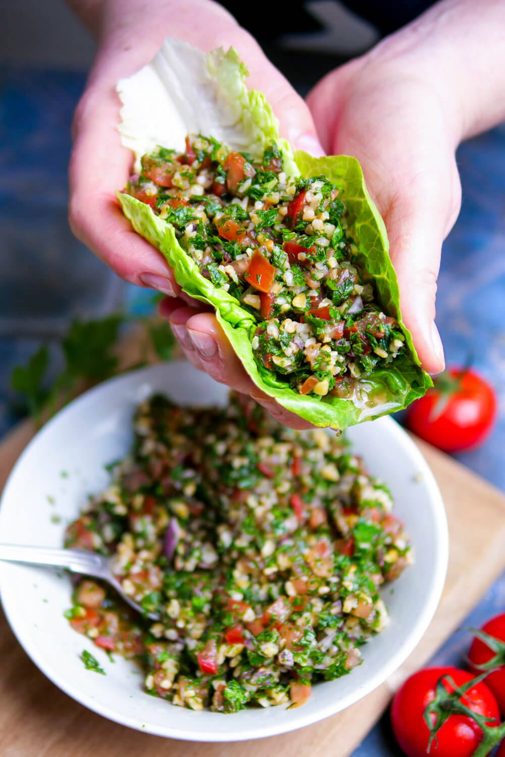 Tabouelh-Salat im Salatblatt mit zwei Hängen gehalten.