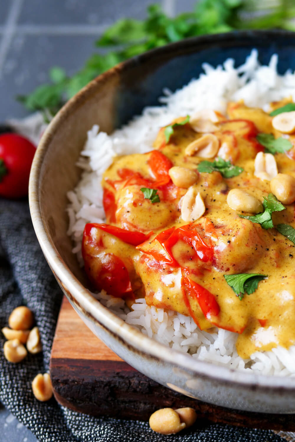 Erdnuss-Curry mit Reis auf einem Teller angerichtet.